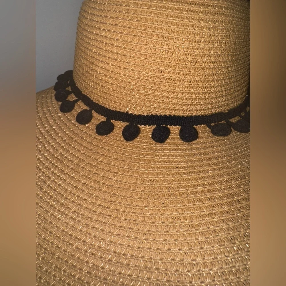 Hundred hearts straw oversized sun hat with black poms around the crown